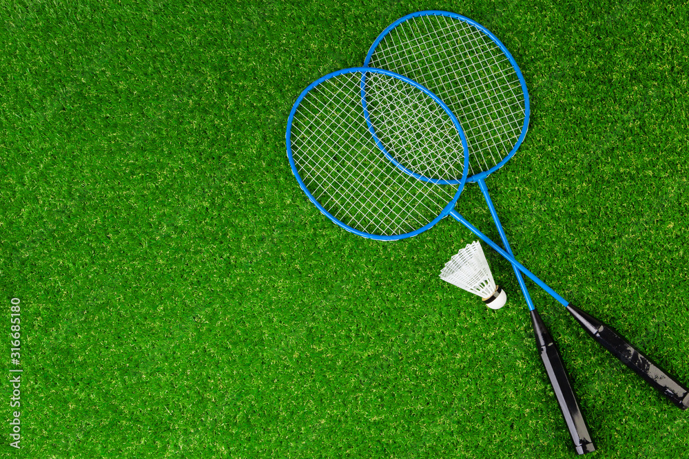 Badminton game rackets and shuttlecock on grass