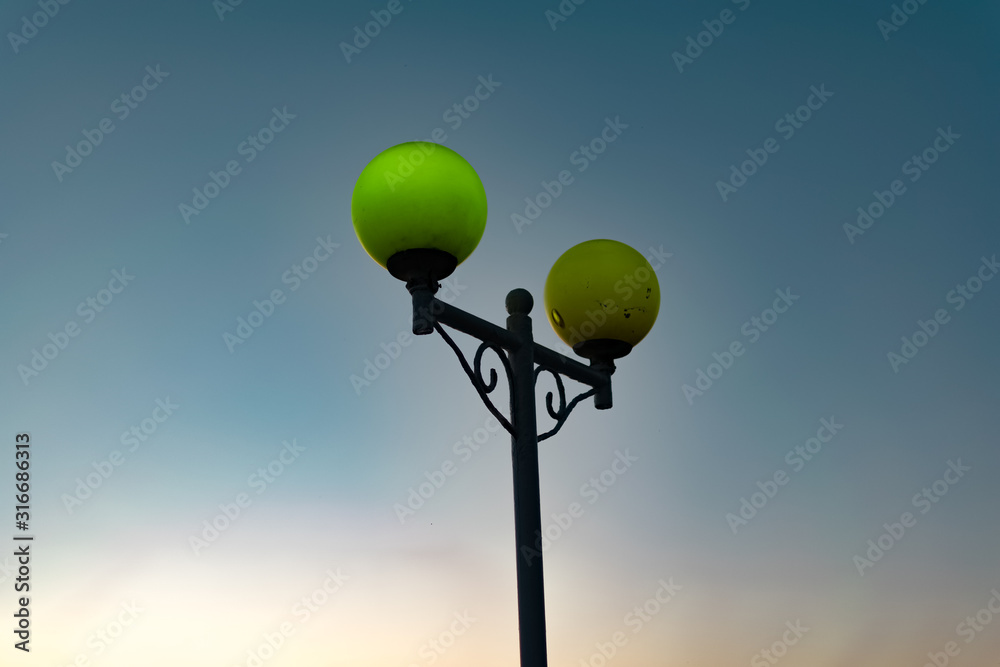 Bright and colorful lights on the waterfront at dusk and night, seascape, green and yellow light, blue starry sky. Russia, the village of Divnomorskoye. Round, glowing balls. Bright and colorful lights on the waterfront at dusk and night, seascape, green and yellow light, blue starry sky. Russia, the village of Divnomorskoye. Round, glowing balls.