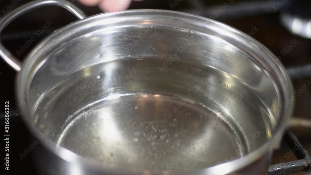 adds salt to a pot of water adds salt to a pot of water