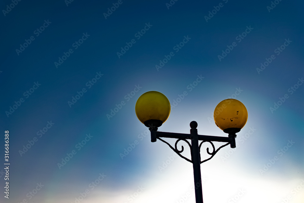 Bright and colorful lights on the waterfront at dusk and night, seascape, green and yellow light, blue starry sky. Russia, the village of Divnomorskoye. Round, glowing balls.