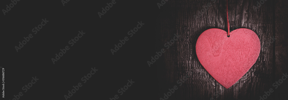 Fototapeta premium Red heart shape on dark wooden background