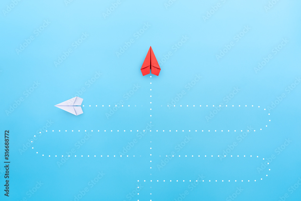 Business concept for new ideas creativity and innovative solution, Red paper plane in one individual pointing in the different way - obrazy, fototapety, plakaty 