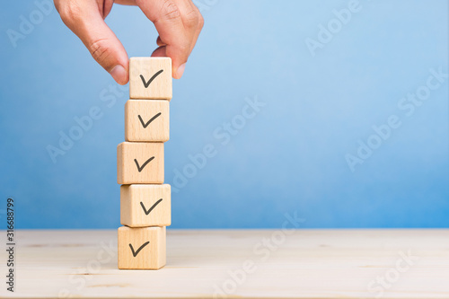 Checklist concept, Check mark on wooden blocks, blue background with copy space photo