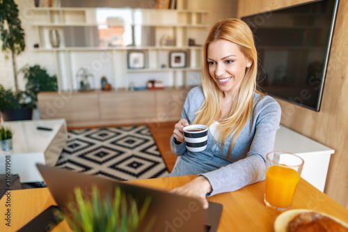 Smiling woman with laptop at home office