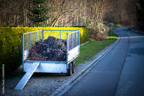 Kompost und Gartenabfälle auf einem Anhänger mit Rampe für eine Schubkarre. photo