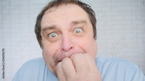 Portrait of funny businessman chewing tie from an unexpected fright in office, humor.