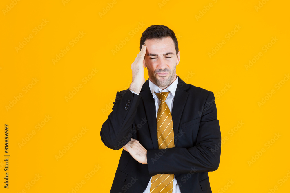 Business man wearing blacksuit have a headache sign on orange yellow background. Business man wearing blacksuit have a headache sign on orange yellow background.