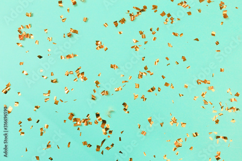 Golden flying sparkles on blue holiday background. Festive backdrop for your projects. - Image