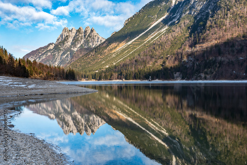 Predil lake in winter dress. Ice and reflections on the water. Tarvisio, Italy
