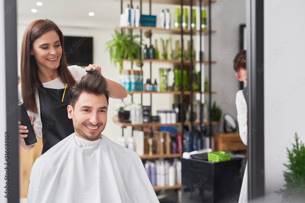 Smiling male customer sitting in hair salon