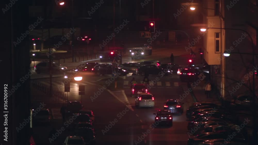 Aerial view of the city intersection with traffic and pedestrians at the crossing. Nightlife in the city of Warsaw, Poland. Aerial view of the city intersection with traffic and pedestrians at the crossing. Nightlife in the city of Warsaw, Poland.