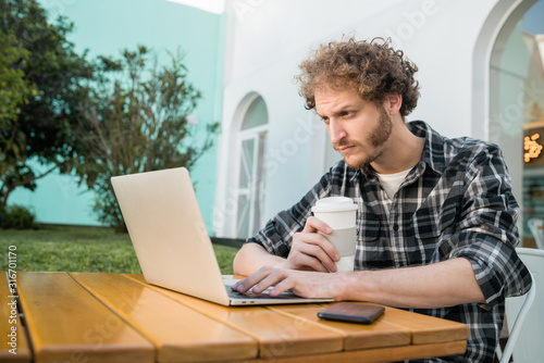 Young man using his laptop in a coffee shop.
