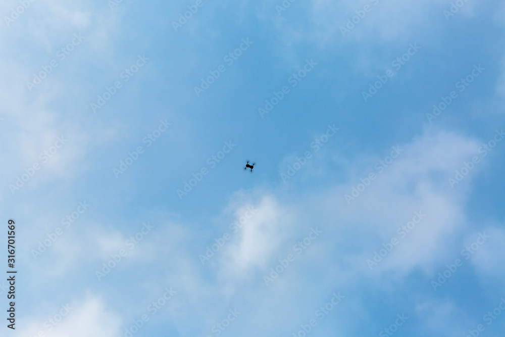 quadrocopter in the blue sky with clouds