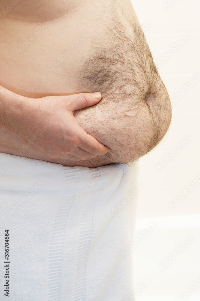 Fat man holding his belly in studio Fat man holding his belly in studio