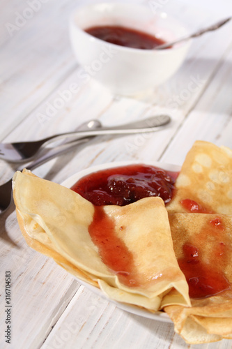 Thin pancakes with strawberry jam