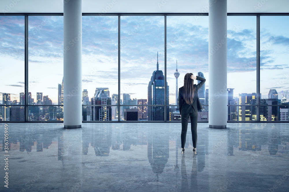 Fototapeta premium Businesswoman standing in empty office interior