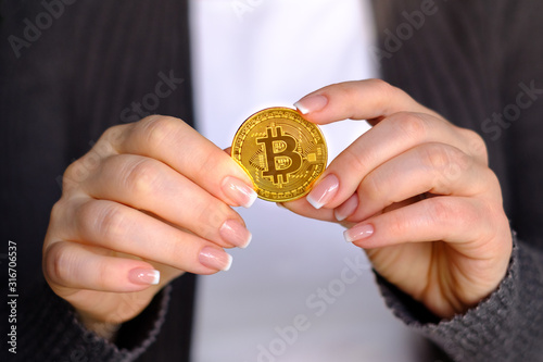 Golden bitcoin in a beautiful female hand. Bitcoin cash coin concept. Symbol of cryptocurrency.