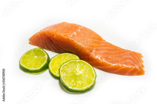 A piece of salted salmon with greens closeup. Red fish on a white background