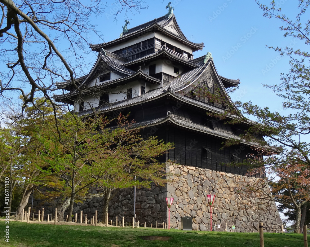Alte Festung in Mitteljapan hinter Ästen und Bäumen Alte Festung in Mitteljapan hinter Ästen und Bäumen