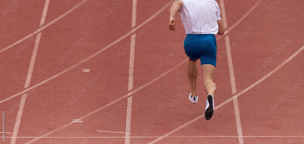 Male athlete running on stadium track, dynamic run of sprinter in a stadium Male athlete running on stadium track, dynamic run of sprinter in a stadium