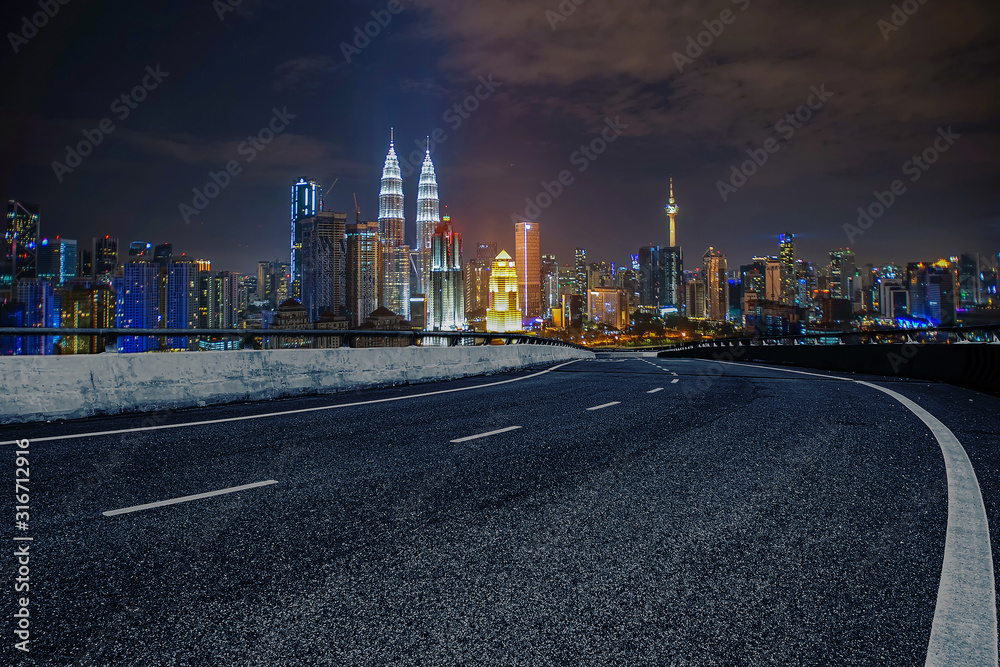 Empty curve road or highway with a view of city night background scene.