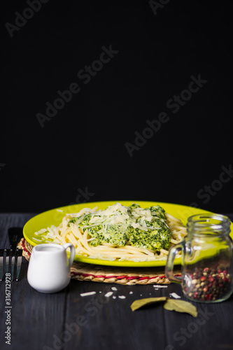 pasta with cheese cream sauce and spinach on a dark wooden background