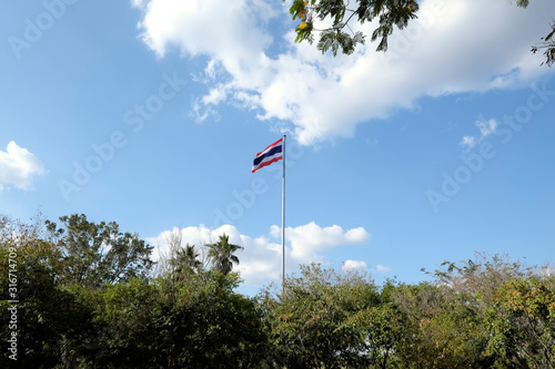 Thailand flag in the wind with clouds and blue sky background