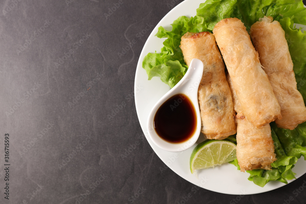 spring roll and soy sauce in plate spring roll and soy sauce in plate