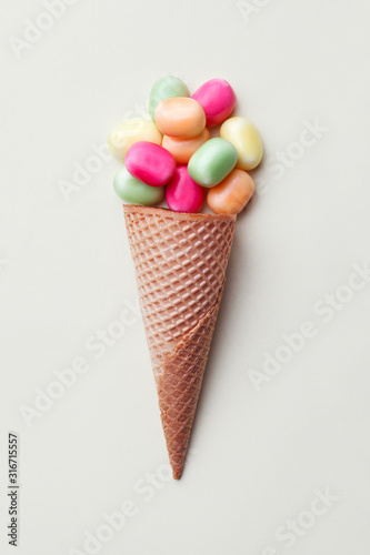 various sweets, colorful  candies arranges in ice cream cone, flat layout, minimal design, top view