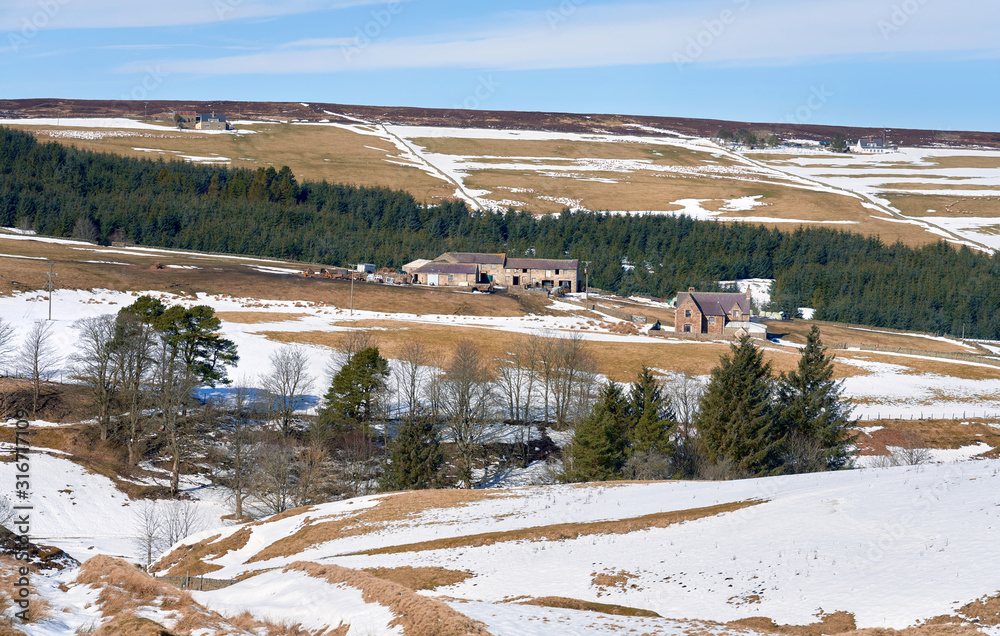 Farm buildings on the remote snow covered moors of Boltshope in winter near Blanchland, England, UK.
