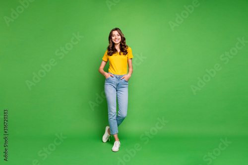 Full length body size view of her she nice attractive lovely cheerful cheery content wavy-haired girl holding hands in pockets isolated over bright vivid shine vibrant green color background