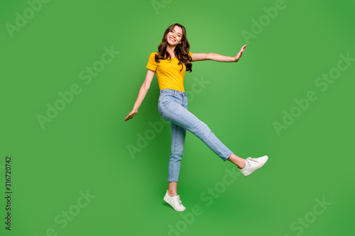 Full length body size view of her she nice attractive lovely charming cheerful cheery girlish wavy-haired girl walking having fun isolated on bright vivid shine vibrant green color background
