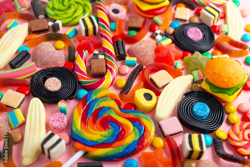 mixed colorful sweets and candy over pink like festive background