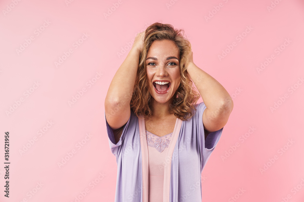 Image of young excited woman screaming and grabbing her head