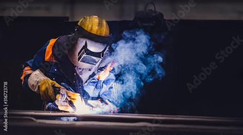 Photo Worker welding in a factory.