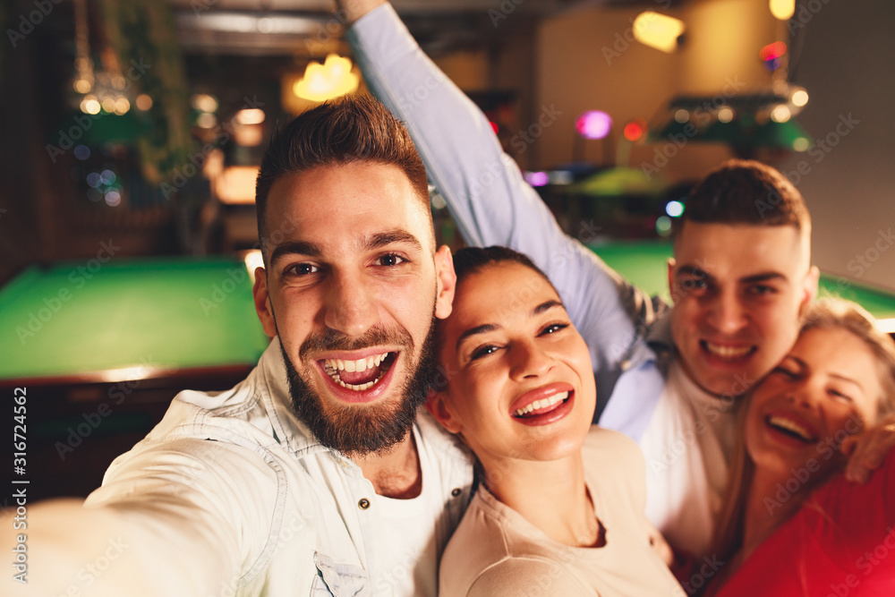 Group of young people having fun in a night out in billiards club and taking selfie Group of young people having fun in a night out in billiards club and taking selfie