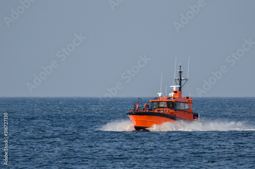 PILOT BOAT -  Orange auxiliary boat on the water