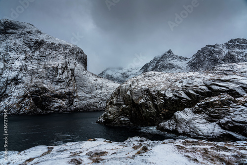 Scenic Nordland landscape photography of snowy fjord with mountains. Lofoten islands, Norway.