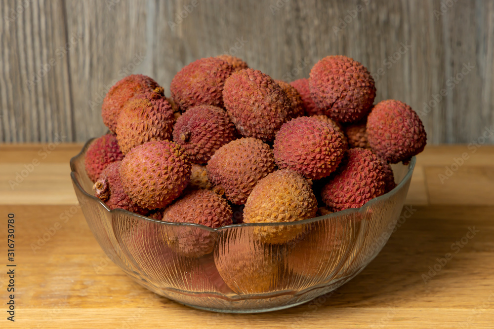 Lychee. Bowl with lychee on a wooden background. Lychee. Bowl with lychee on a wooden background.