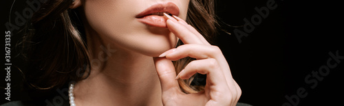 panoramic shot of woman touching lips isolated on black