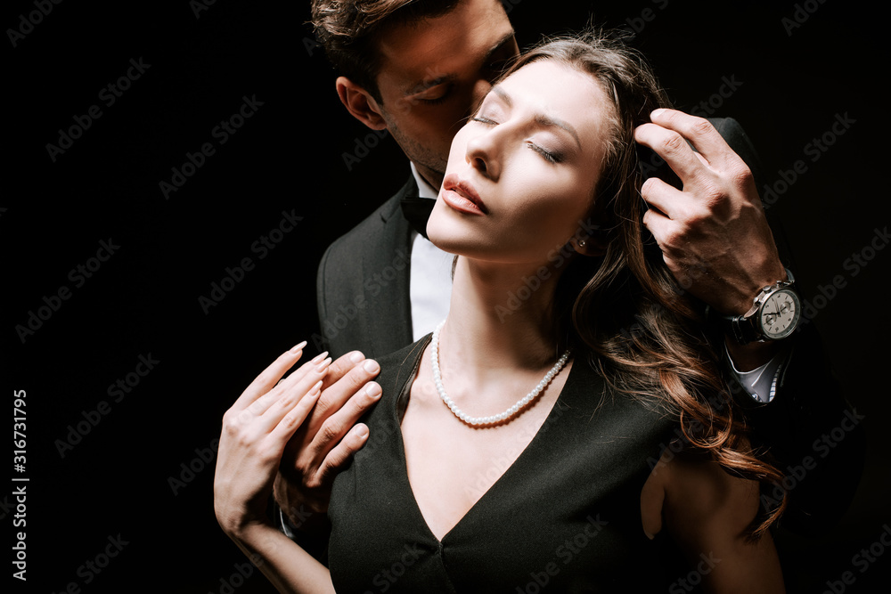 man touching hair of attractive woman in dress isolated on black Stock  Photo | Adobe Stock