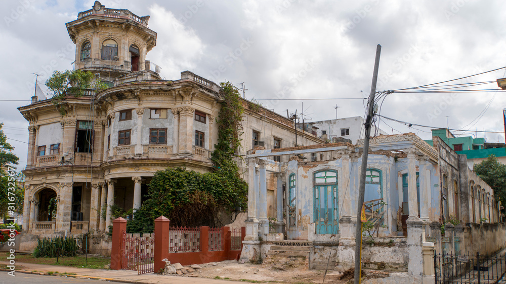 dilapidated building in havana with a yellow convertible classic car, cuba
