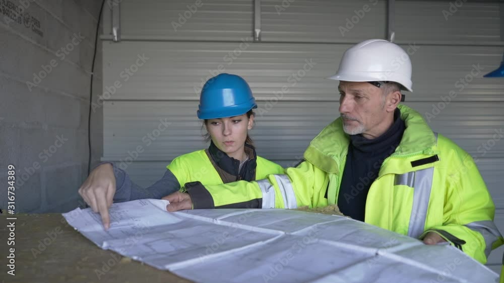 Engineering instructor working on building site with apprentice Engineering instructor working on building site with apprentice