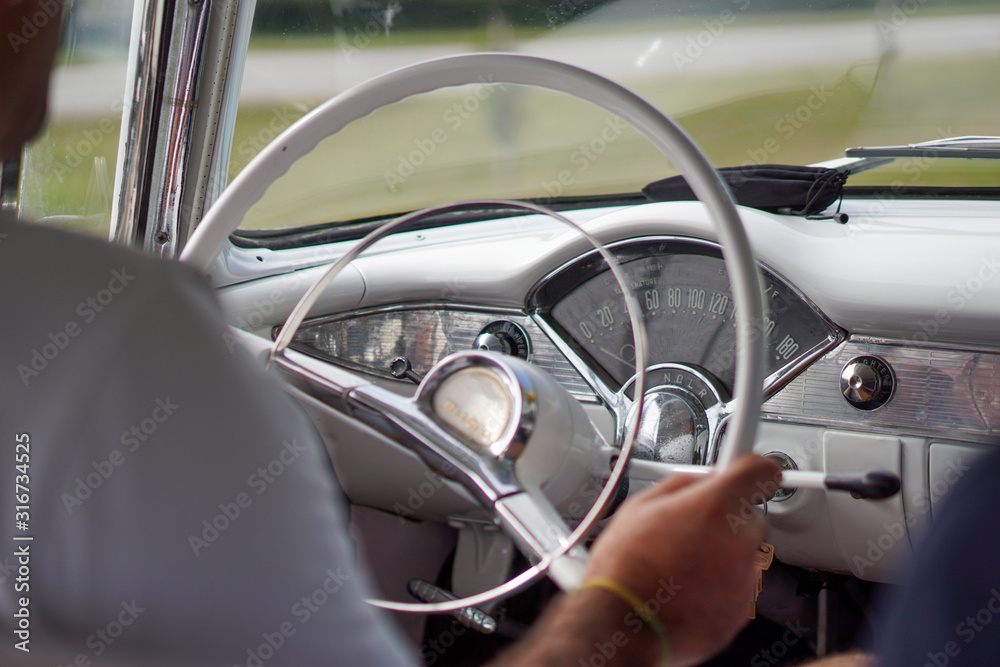 inside a cuban classic car with the driver and the steering wheel, cuba