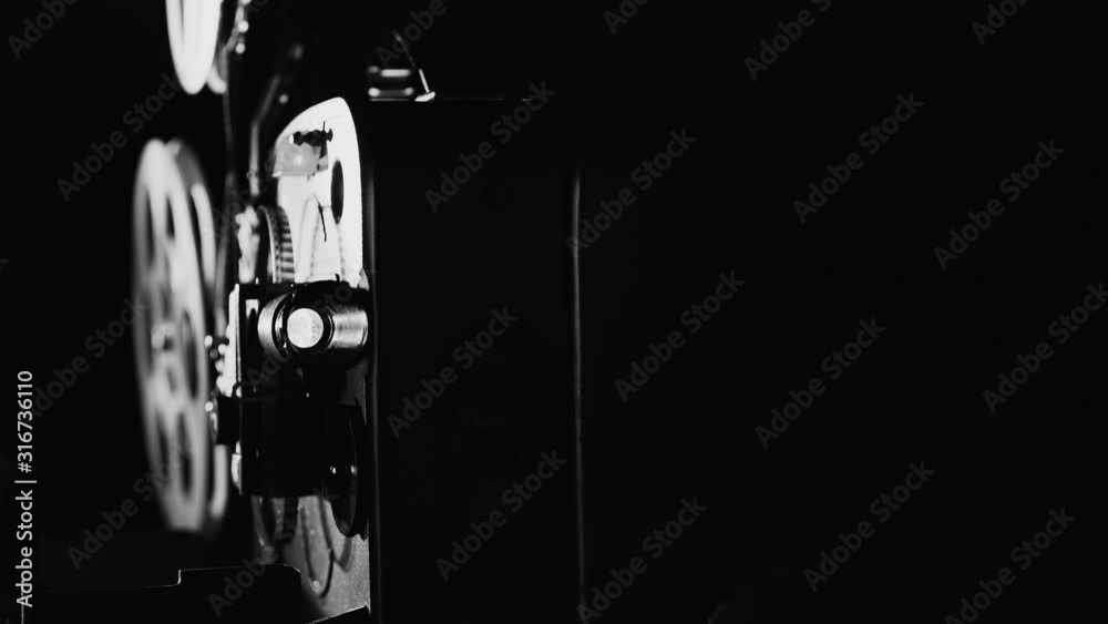 Front view of an old 8mm film projector in dark room. Monochrome image.