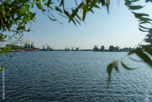 Willow branch with heart shape. In the background port cranes in harbor. Dabie Lake in Szczecin, Poland.