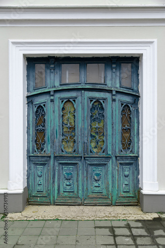 Retro vintage wooden door with metal and wood carvings on the european public building exterior.