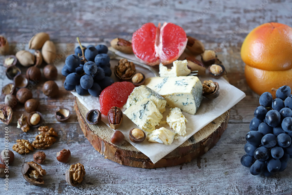 Mix of cheeses, nuts and fruits. Healthy snack. Appetizer to wine. Selective focus. Mix of cheeses, nuts and fruits. Healthy snack. Appetizer to wine. Selective focus.