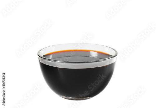 Soy sauce in a glass bowl close-up on a white background
