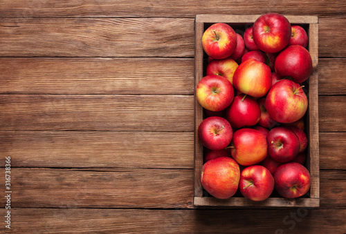 red apples in box on wooden table